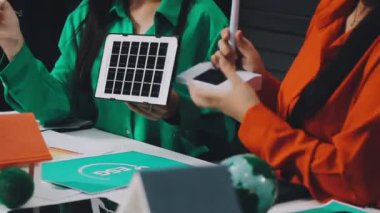 Genç iş kadını yeşil enerjili bir tablet ve yazı kullanıyor..