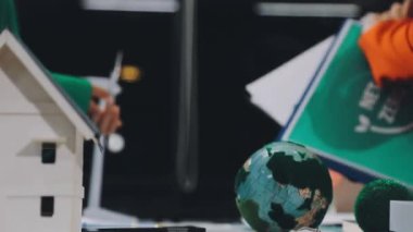Elinde Dünya gezegeninin maketi olan minyatür bir model tutan bir insan..