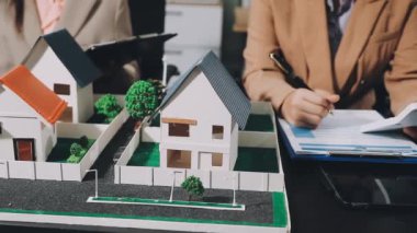 Emlakçı ev modelini müşteriye gösteriyor.