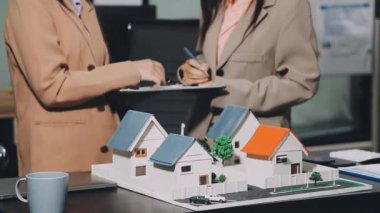 Emlakçı ve ev modeli.