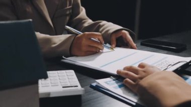 Ofisteki genç işadamı belgelerle çalışıyor.