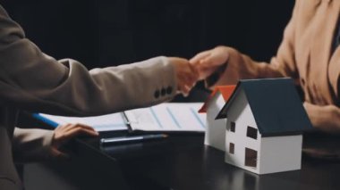 Emlakçı, kontratı imzaladıktan sonra müşteriye ev anahtarlarını gösteriyor.