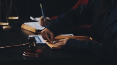 Takım elbiseli ve kravatlı işadamı tokmak ve belgeleri ofisinde tutuyor..