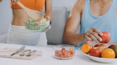 Mutfaktaki kadın taze salata yiyor.