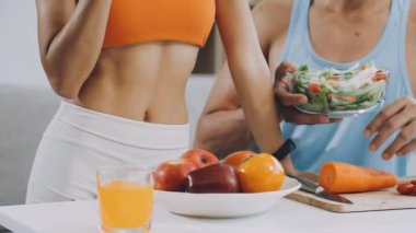 Kadın ve erkek bir bardak meyve suyuyla mutfakta..