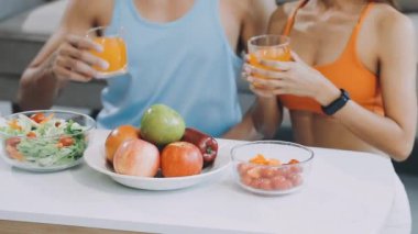 Genç bir kadın ve bir adam mutfakta kahvaltı yapıyor.