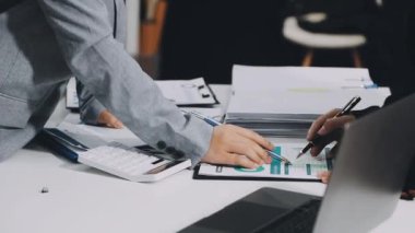 İş adamı, masada hesap makinesi ve tabletle finansal verileri analiz ediyor.