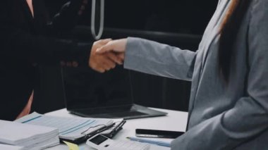 İş kadını modern ofisteki ortağıyla tokalaşıyor..