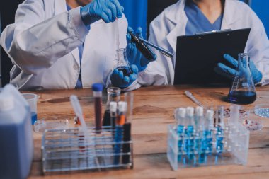 Laboratuvarda kan testi. Dispanser ile çalışan laboratuvar asistanı. Kanlı vakum tüpleri..