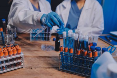 Laboratuvarda kan testi. Dispanser ile çalışan laboratuvar asistanı. Kanlı vakum tüpleri..