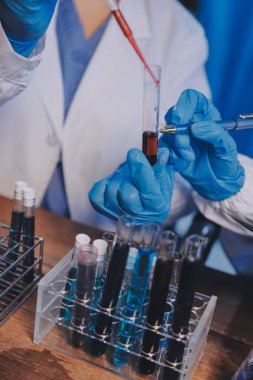 Laboratuvarda kan testi. Dispanser ile çalışan laboratuvar asistanı. Kanlı vakum tüpleri..