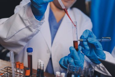Laboratuvarda kan testi. Dispanser ile çalışan laboratuvar asistanı. Kanlı vakum tüpleri..