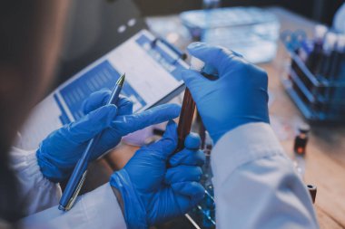 Laboratuvarda kan testi. Dispanser ile çalışan laboratuvar asistanı. Kanlı vakum tüpleri..