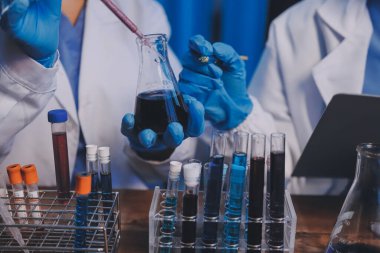 Laboratuvarda kan testi. Dispanser ile çalışan laboratuvar asistanı. Kanlı vakum tüpleri..