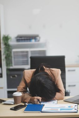 Yorgun ve Asyalı bir kadının portresi ofiste vergi bilgisayarıyla çalışıyor. Üzgün, mutsuz, endişeli, depresyon ya da çalışan hayatı stres konsepti