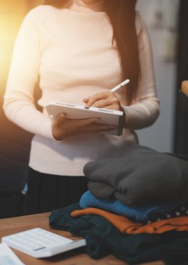 Girişim KOBİ küçük işletme girişimcisi önlük giyen Asyalı kadın dizüstü bilgisayar ve kutu kullanarak çevrimiçi müşterilere, çevrimiçi sme iş fikirlerine satış hazırlamak için siparişleri alır ve gözden geçirir.