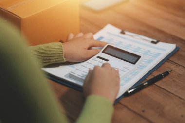 Girişim KOBİ küçük işletme girişimcisi önlük giyen Asyalı kadın dizüstü bilgisayar ve kutu kullanarak çevrimiçi müşterilere, çevrimiçi sme iş fikirlerine satış hazırlamak için siparişleri alır ve gözden geçirir.