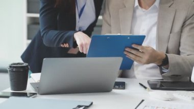 Ofiste dizüstü bilgisayar ve iş ekibiyle çalışan iş adamı