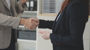 İş kadını ve işadamı ofiste el sıkışıyor