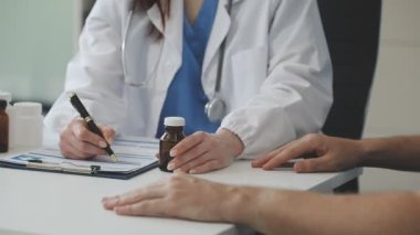 Tıp ceketli doktor elinde bir şişe tutuyor.