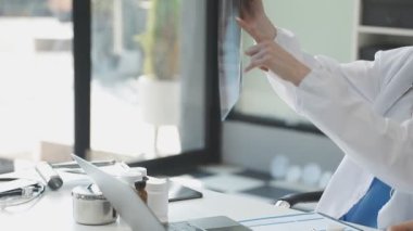 Beyaz önlüklü doktor röntgene bakıyor.