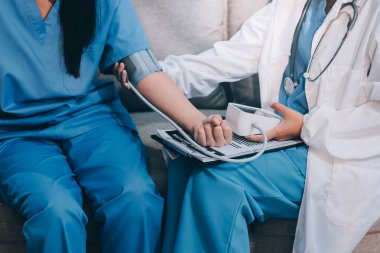 Doktor kadın nabız sayacını hastanın basıncını ölçmek için kullanıyor. Tıbbi kontrol konsepti..