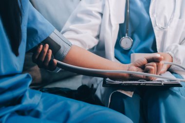 Doktor kadın nabız sayacını hastanın basıncını ölçmek için kullanıyor. Tıbbi kontrol konsepti..