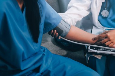 Doktor kadın nabız sayacını hastanın basıncını ölçmek için kullanıyor. Tıbbi kontrol konsepti..