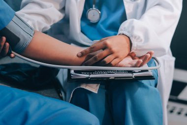 Doktor kadın nabız sayacını hastanın basıncını ölçmek için kullanıyor. Tıbbi kontrol konsepti..