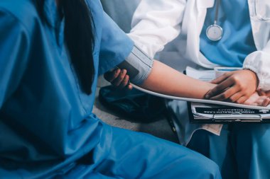 Doktor kadın nabız sayacını hastanın basıncını ölçmek için kullanıyor. Tıbbi kontrol konsepti..