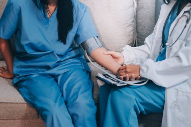 Doktor kadın nabız sayacını hastanın basıncını ölçmek için kullanıyor. Tıbbi kontrol konsepti..