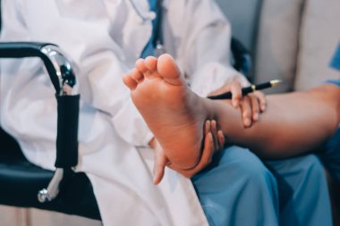 Doktor bir hastaya bacak tedavisi yapıyor.