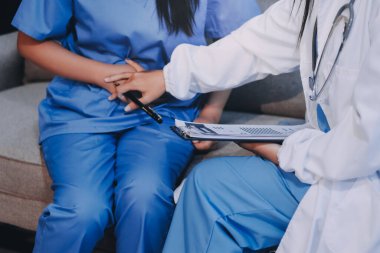 Genç Asyalı kadın doktorların hastalarla ruh sağlığı, iyileşme ve sağlık kliniğinde sağlıklı bir yaşam tarzı hakkında konuştuklarını yakından takip edin. Sağlık hizmetleri.