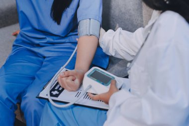 Doktor kadın nabız sayacını hastanın basıncını ölçmek için kullanıyor. Tıbbi kontrol konsepti..