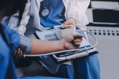 Doktor kadın nabız sayacını hastanın basıncını ölçmek için kullanıyor. Tıbbi kontrol konsepti..