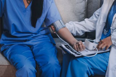 Doktor kadın nabız sayacını hastanın basıncını ölçmek için kullanıyor. Tıbbi kontrol konsepti..