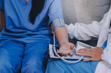 Doktor kadın nabız sayacını hastanın basıncını ölçmek için kullanıyor. Tıbbi kontrol konsepti..