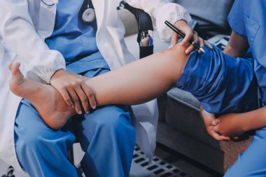 Doktor bir hastaya bacak tedavisi yapıyor.