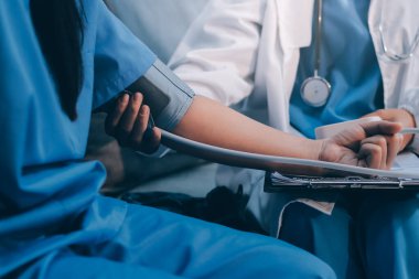 Doktor kadın nabız sayacını hastanın basıncını ölçmek için kullanıyor. Tıbbi kontrol konsepti..