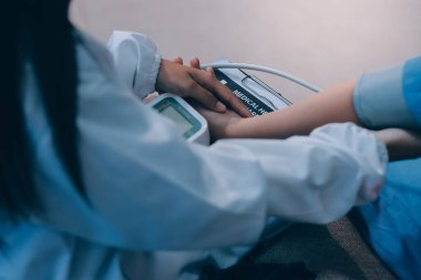 Doktor kadın nabız sayacını hastanın basıncını ölçmek için kullanıyor. Tıbbi kontrol konsepti..