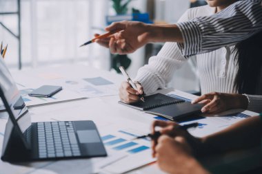 Bir grup genç Asyalı yaratıcı iş adamı beyin fırtınası sunumu, ürün tanıtımı, planlama, strateji, yeni iş geliştirme, ofiste yeni bir başlangıç projesi üzerinde tartışıyorlar..