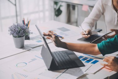 Bir grup genç Asyalı yaratıcı iş adamı beyin fırtınası sunumu, ürün tanıtımı, planlama, strateji, yeni iş geliştirme, ofiste yeni bir başlangıç projesi üzerinde tartışıyorlar..