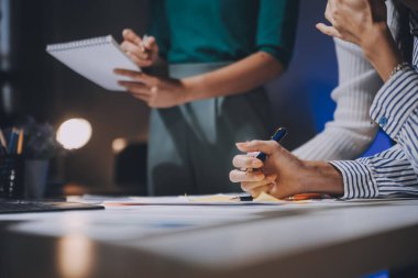 Bir grup genç Asyalı yaratıcı iş adamı beyin fırtınası sunumu, ürün tanıtımı, planlama, strateji, yeni iş geliştirme, ofiste yeni bir başlangıç projesi üzerinde tartışıyorlar..