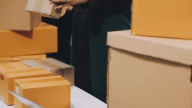Bir kadın karton kutu paketliyor..