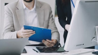 Tablet üzerinde çalışan takım elbiseli genç iş kadını.