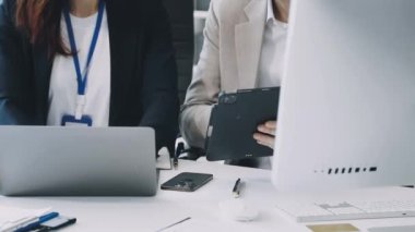 Genç iş adamları ofiste dizüstü bilgisayarla çalışıyorlar..