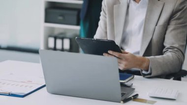 Ofisteki bilgisayarlı ve akıllı telefonlu bir iş adamı.