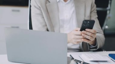 Ofiste akıllı telefonla çalışan bir işadamı.