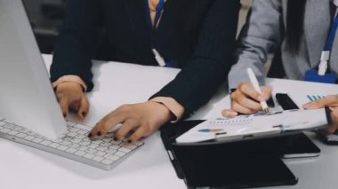 Ofis masasındaki bilgisayarda çalışan genç bir iş kadını..