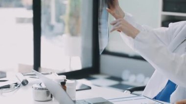 Beyaz önlüklü ve steteskoplu genç bayan doktor röntgen görüntüsüne bakıyor..